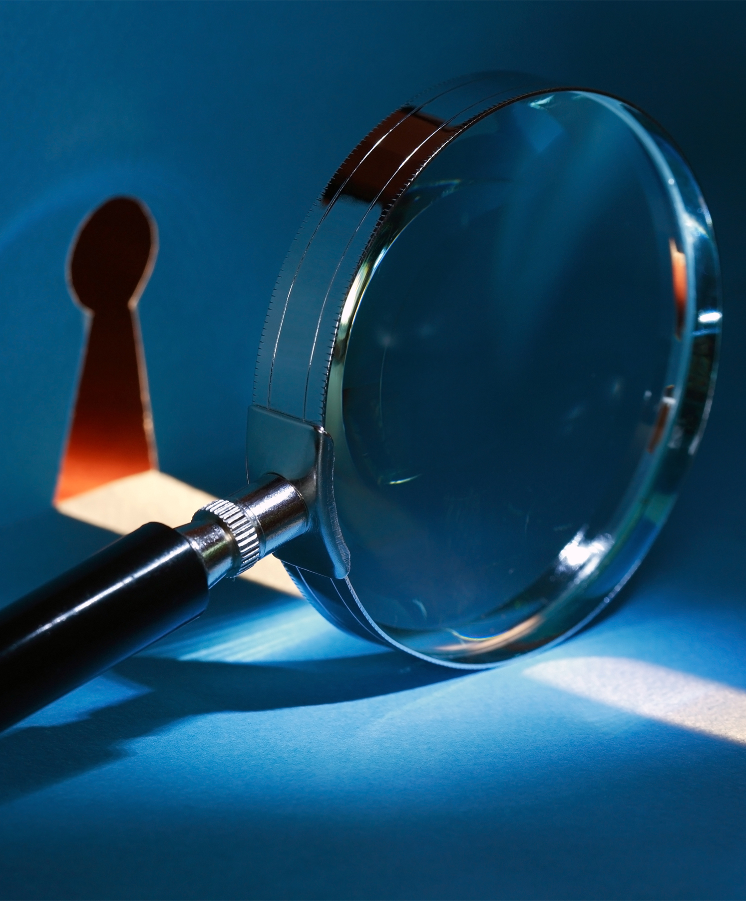 Spying concept. Magnifying glass near keyhole with beam of light