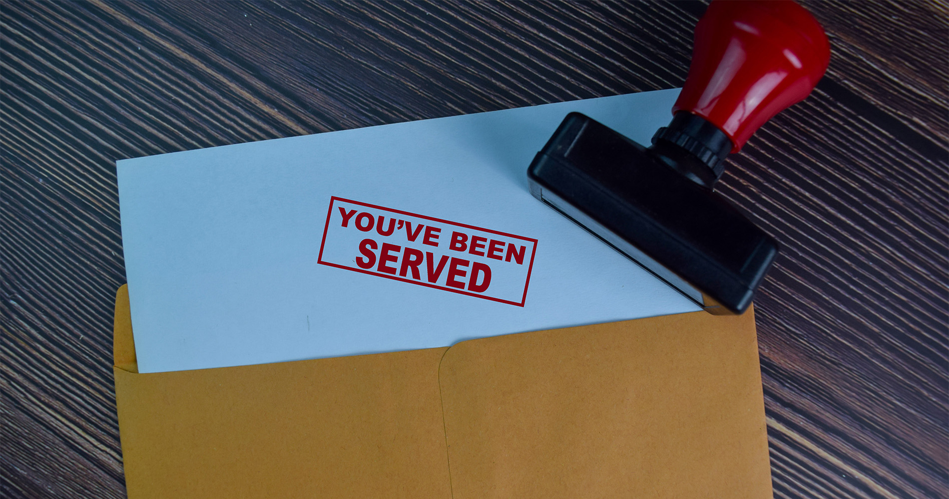 Process Services in Jackson MI You've Been Served text on document above brown envelope.